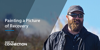 A Veteran standing outdoors and looking away while smiling. Text: Painting a Picture of Recovery. 